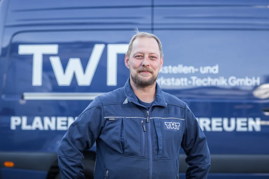 Ronny Drescher steht vor einem blauen Transporter der TWT