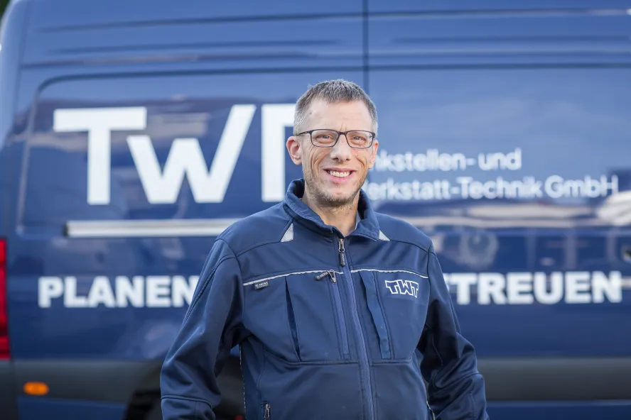 Michael Litzenberger steht vor einem blauen Transporter der TWT