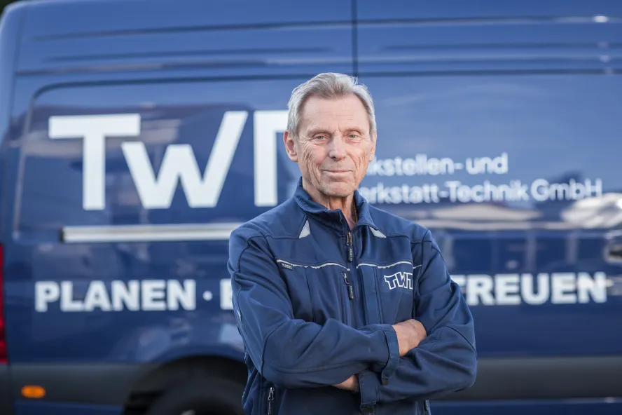 Werner Friedrich steht vor einem blauen Transporter der TWT