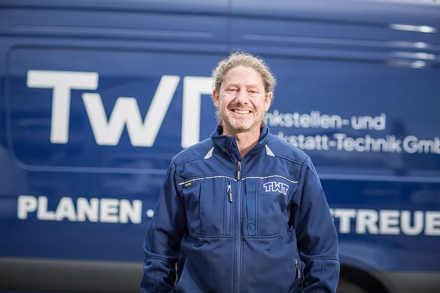 Rico Grune steht vor einem blauen Transporter der TWT